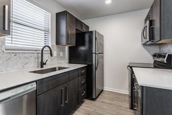 A kitchen with a black fridge and a white counter top